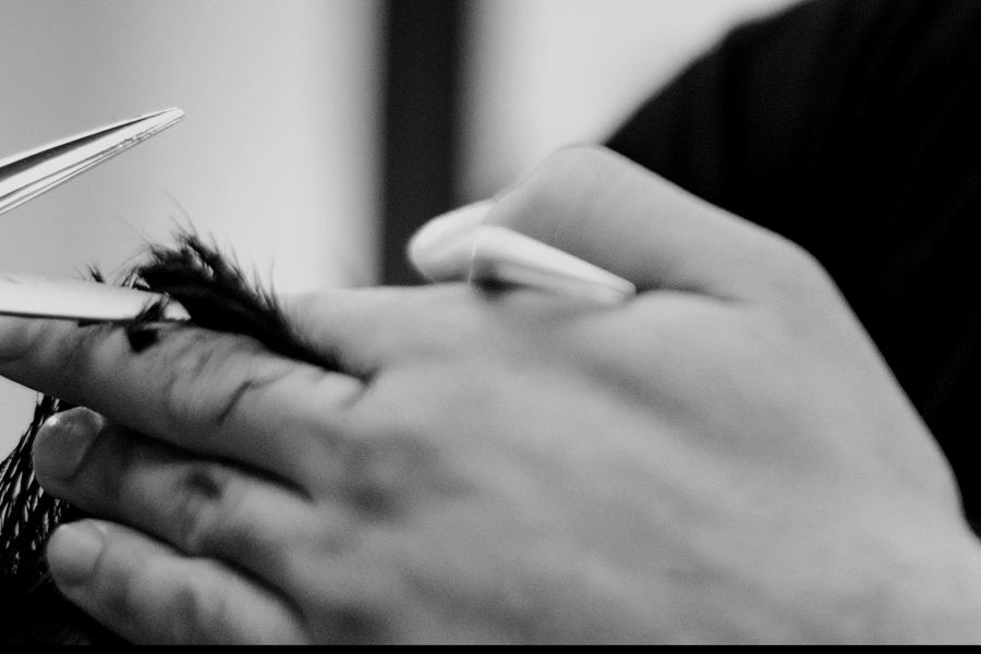 Hands cutting hair with scissors